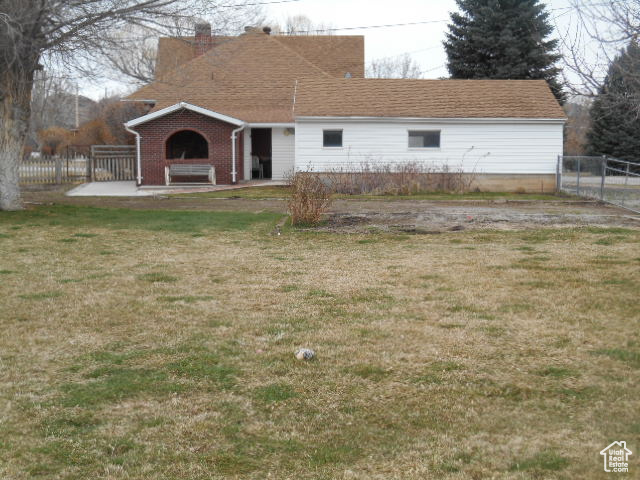 Back of property with a yard and a fireplace