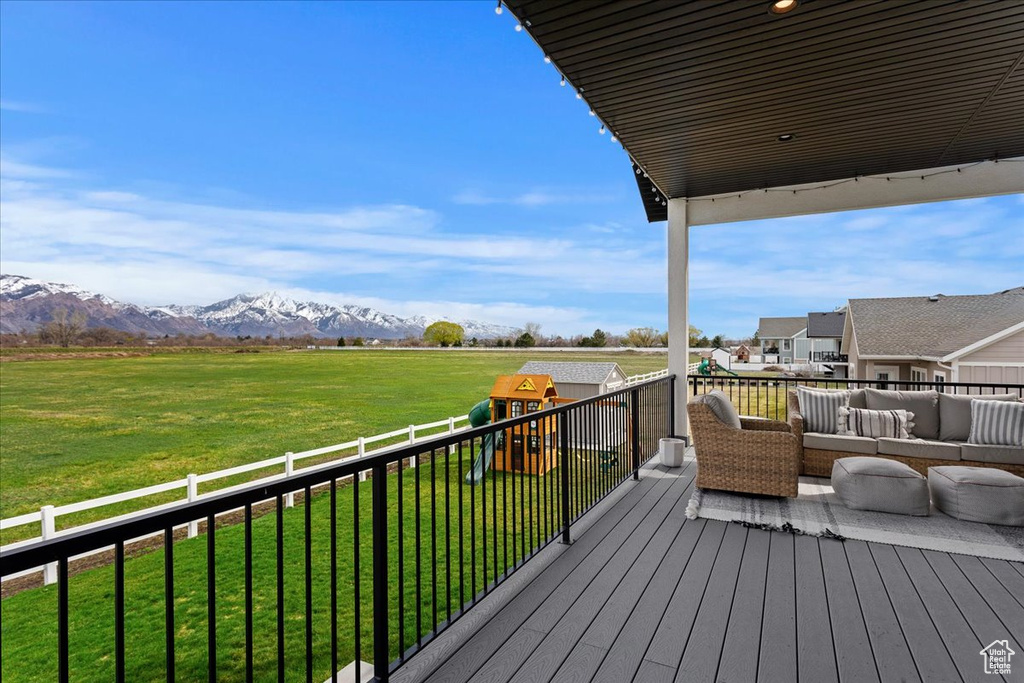 Deck with a lawn, an outdoor hangout area, and a mountain view