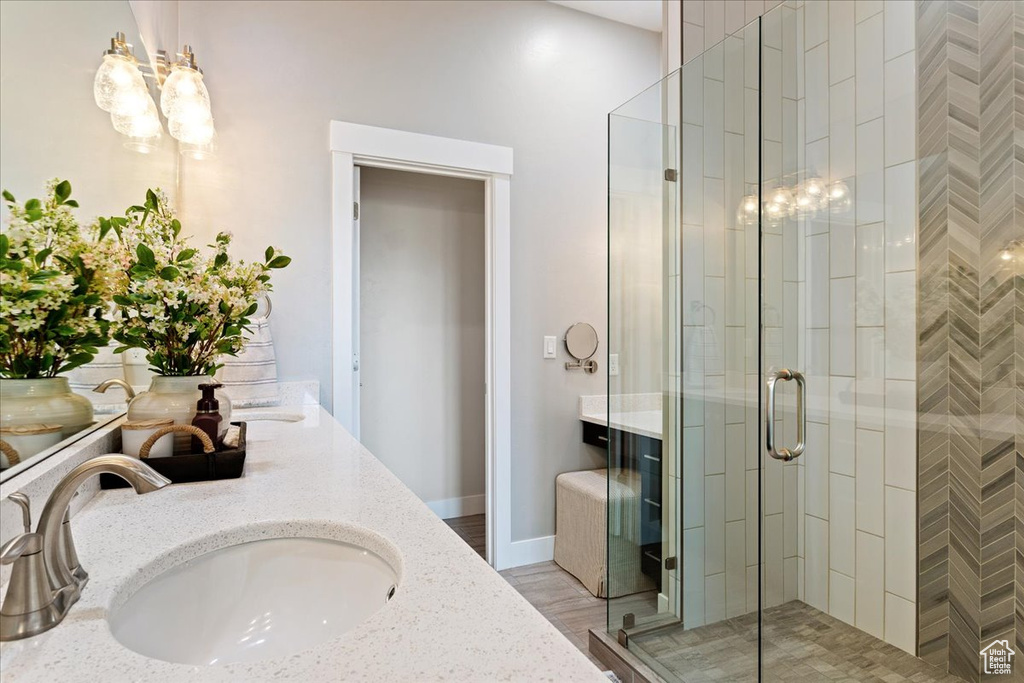 Bathroom with dual vanity, wood-type flooring, and walk in shower
