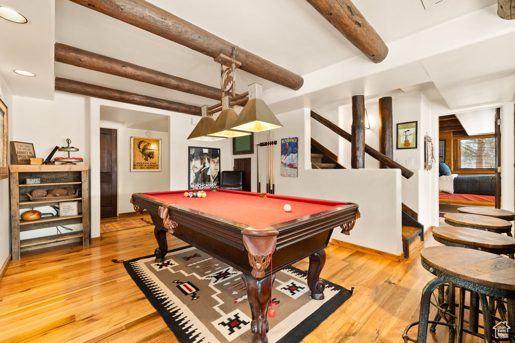 Recreation room with beamed ceiling, pool table, and light hardwood / wood-style flooring
