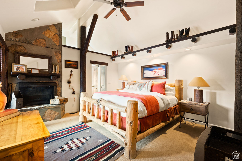 Bedroom with a fireplace, lofted ceiling, ceiling fan, and light colored carpet