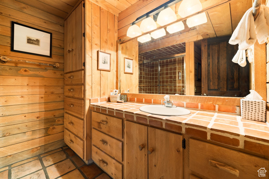 Bathroom with wood walls, tile floors, oversized vanity, and wood ceiling