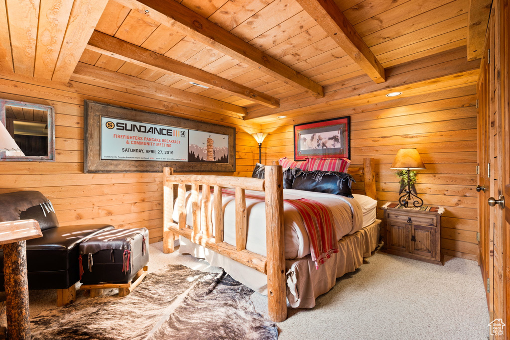 Carpeted bedroom with wood ceiling, wooden walls, and beamed ceiling