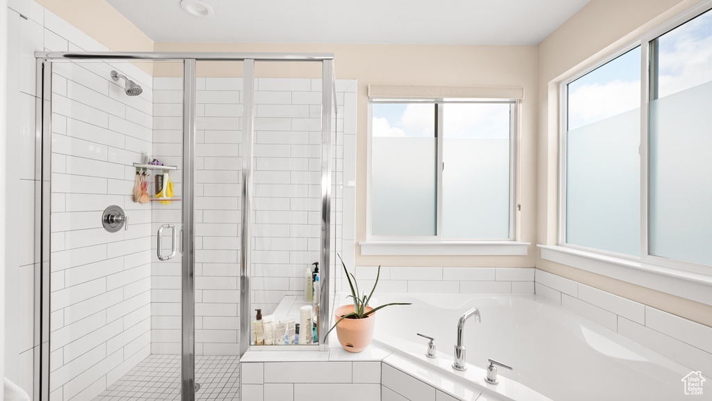 Bathroom with shower with separate bathtub and a healthy amount of sunlight