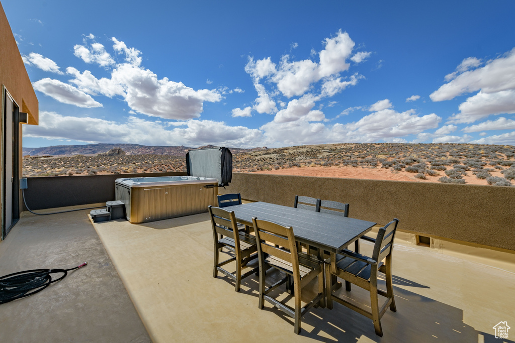 View of patio featuring a mountain view and a hot tub