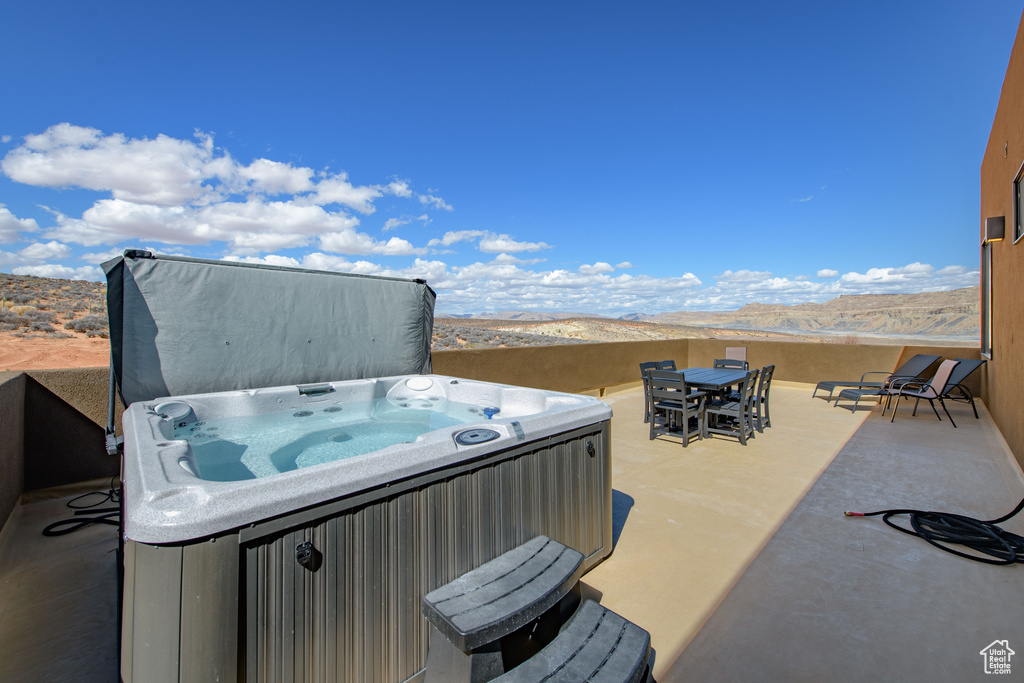 View of patio / terrace featuring a mountain view and a hot tub