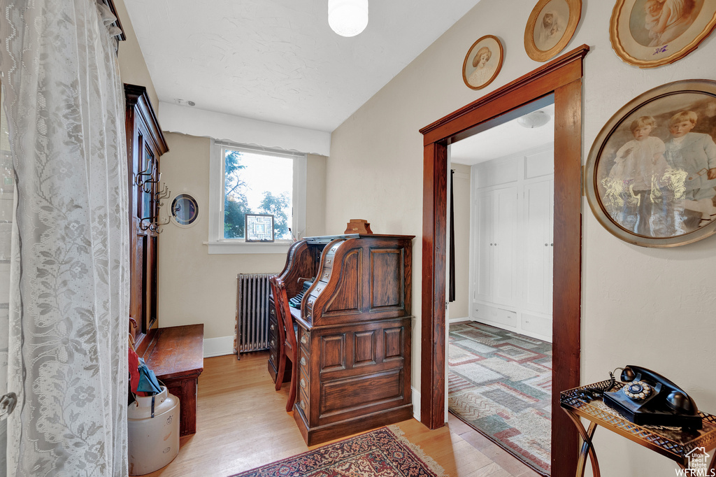 Interior space with radiator heating unit and light hardwood / wood-style flooring