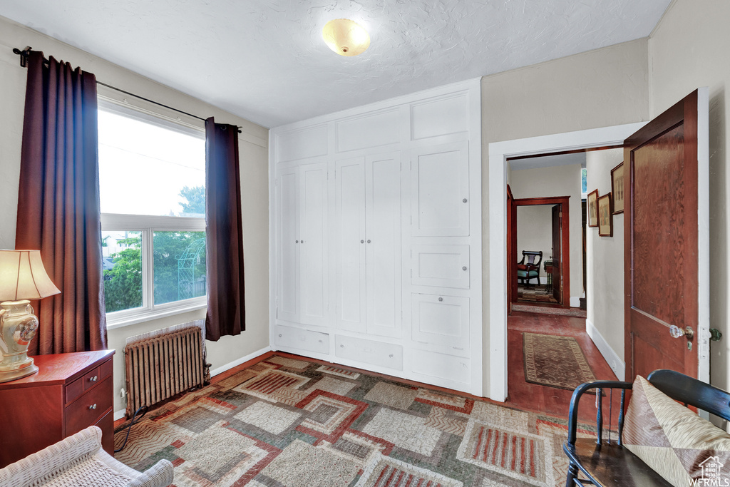 Interior space featuring dark hardwood / wood-style floors and radiator heating unit