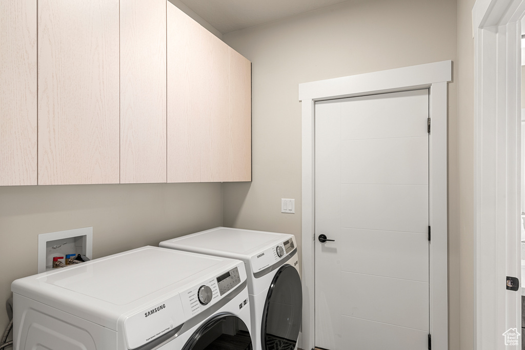 Laundry room featuring independent washer and dryer, cabinets, and hookup for a washing machine