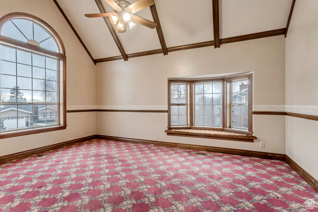 Carpeted empty room featuring high vaulted ceiling and ceiling fan