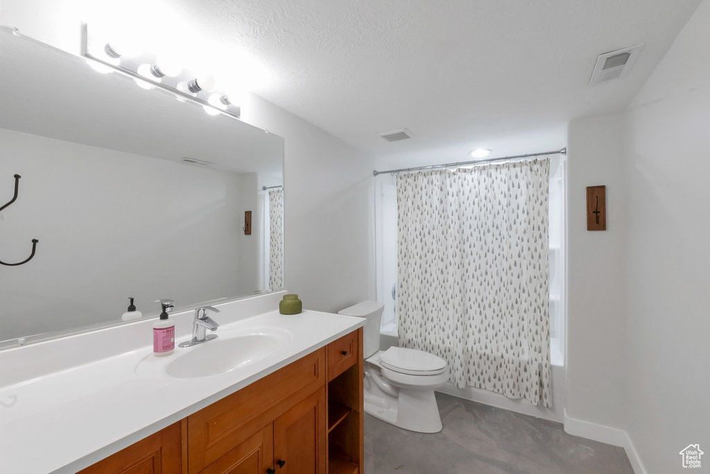 Full bathroom featuring toilet, vanity, and shower / bath combo with shower curtain
