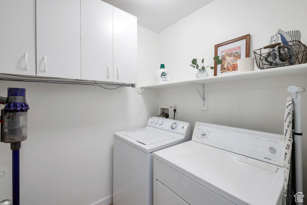 Laundry area with cabinets, independent washer and dryer, and hookup for a washing machine