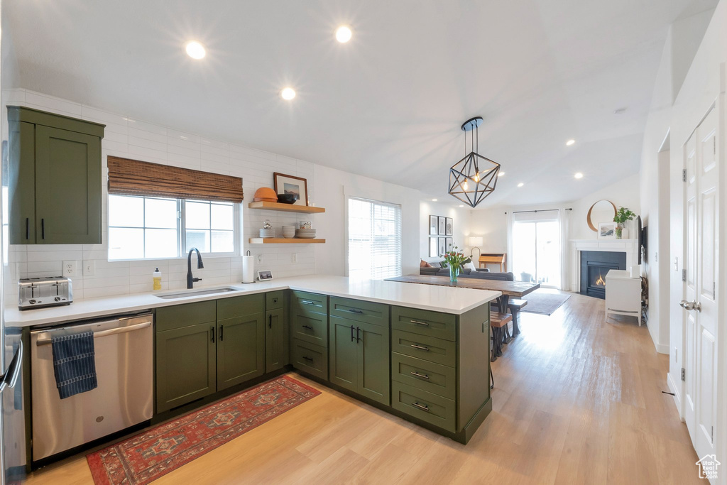 Kitchen with sink, dishwasher, a wealth of natural light, tasteful backsplash, and light wood-type flooring