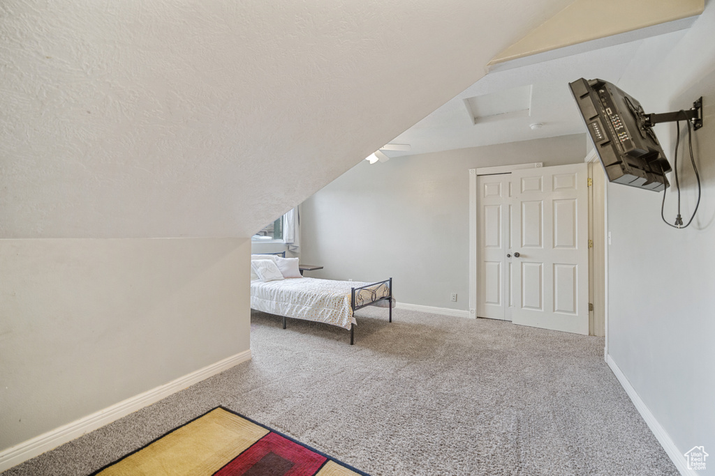 Bedroom featuring a textured ceiling, carpet, and vaulted ceiling