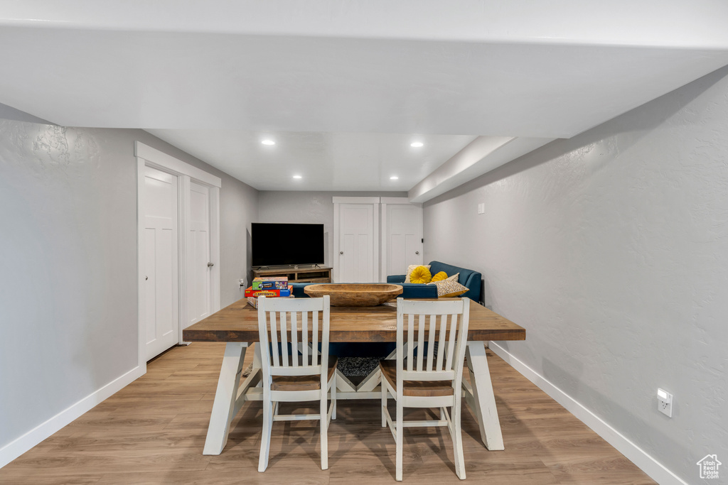 Dining space featuring a tray ceiling and light hardwood / wood-style flooring