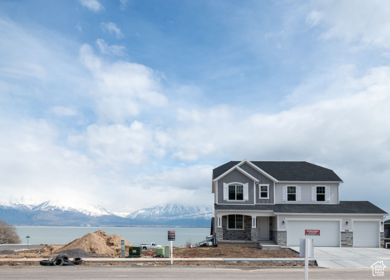 View of front of property featuring a water and mountain view and a garage