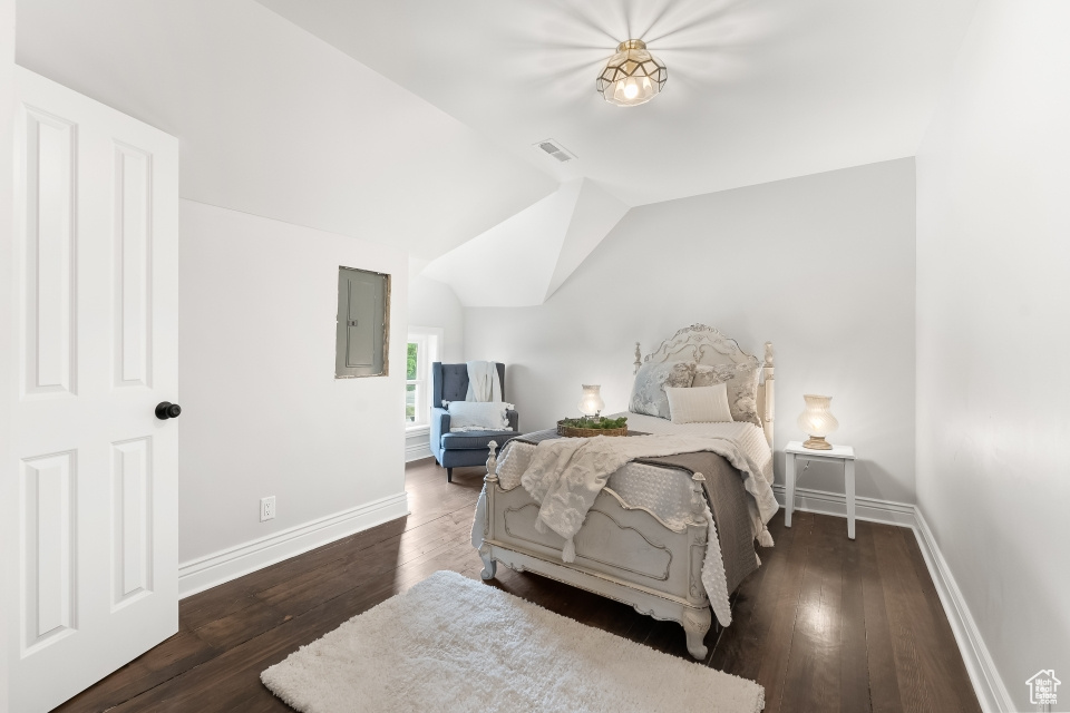 Bedroom featuring lofted ceiling and dark hardwood / wood-style flooring