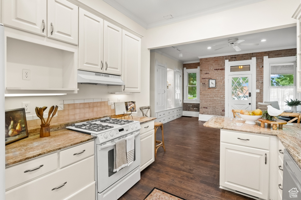 Kitchen featuring gas range gas stove, white cabinets, and ceiling fan