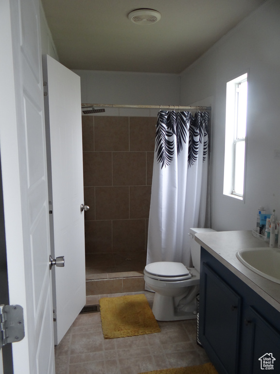 Bathroom featuring vanity, tile flooring, a shower with curtain, and toilet
