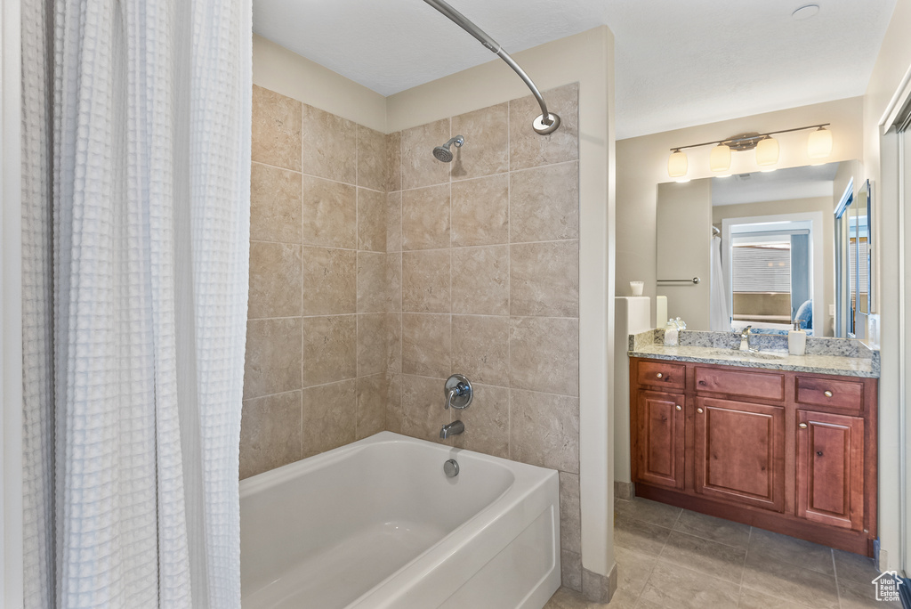 Bathroom featuring vanity, shower / bath combination with curtain, and tile flooring