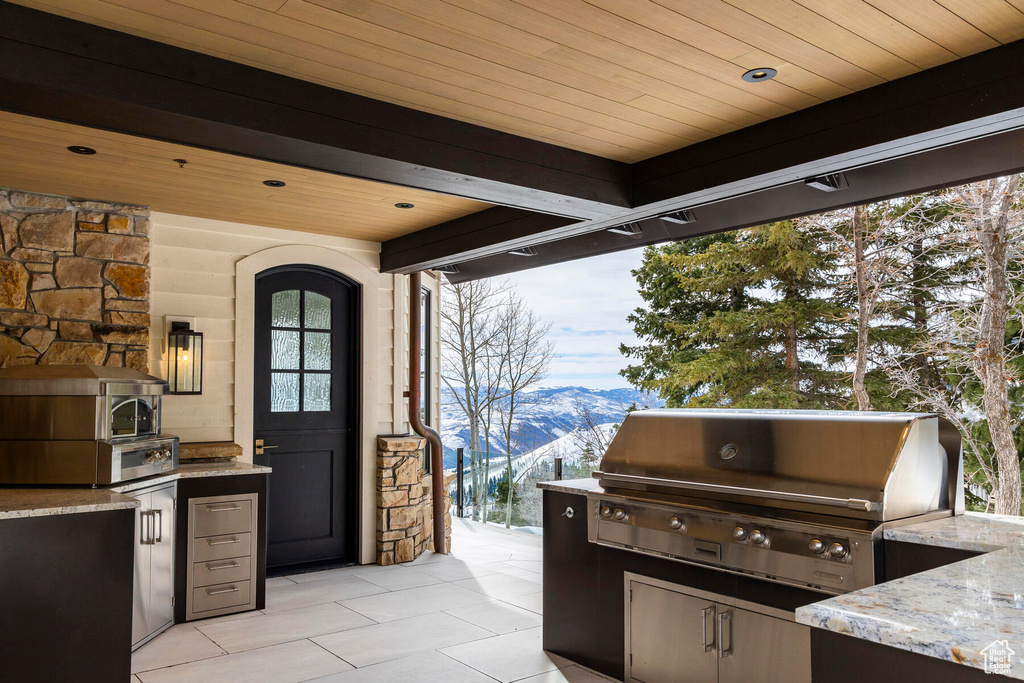 View of terrace featuring a mountain view, area for grilling, and exterior kitchen