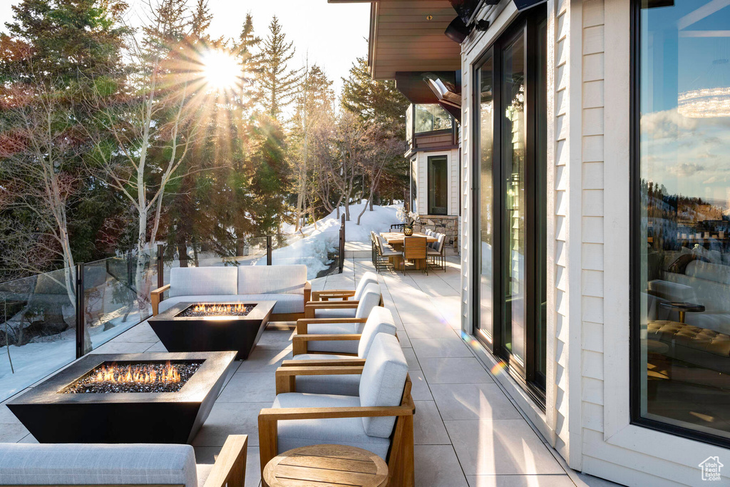 Snow covered patio with an outdoor living space with a fire pit