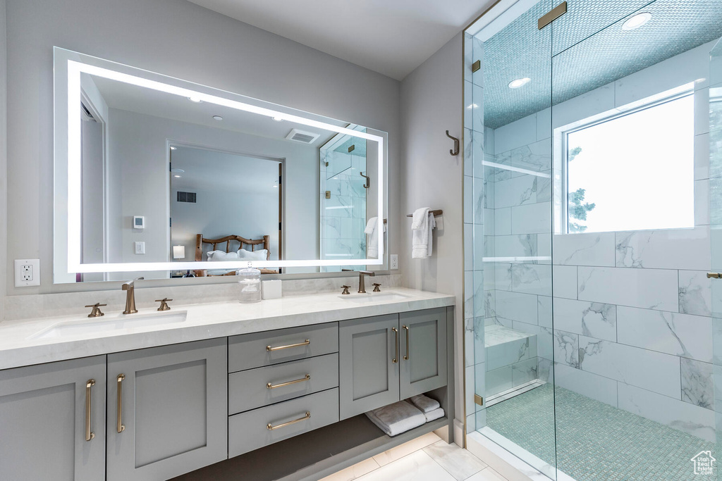Bathroom featuring double vanity, tile floors, and walk in shower