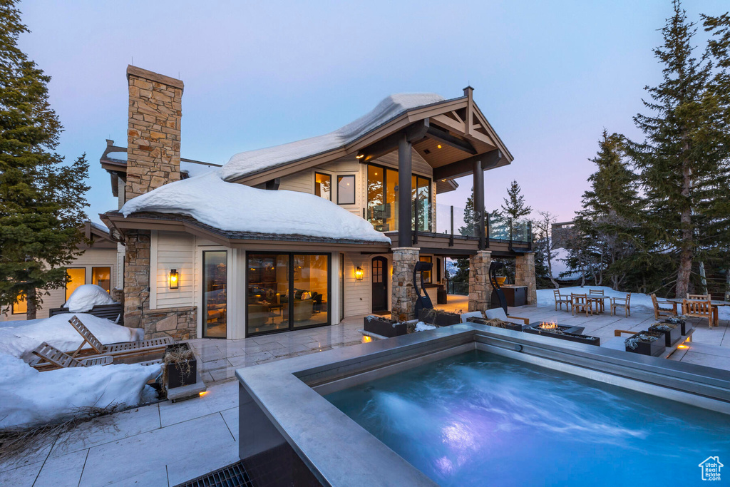 Snow covered pool featuring a patio area and an outdoor fire pit
