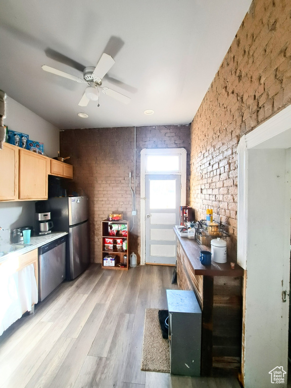 Kitchen featuring ceiling fan, light brown cabinets, brick wall, light hardwood / wood-style flooring, and dishwasher