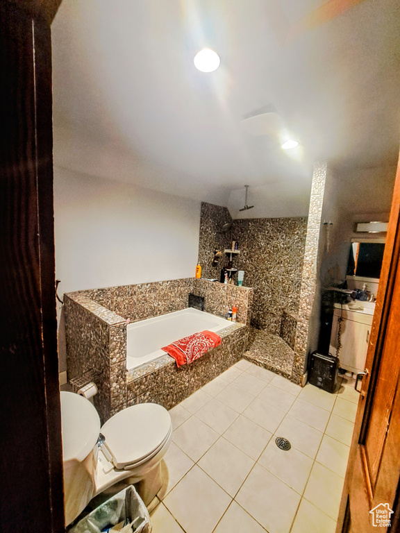Bathroom with tile flooring, a bathtub, and toilet