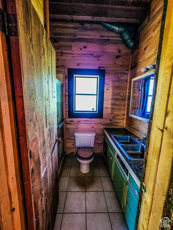 Bathroom featuring wood walls, tile flooring, and toilet