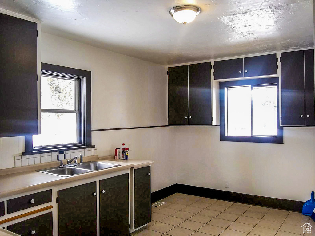 Kitchen with oven, light tile floors, and sink