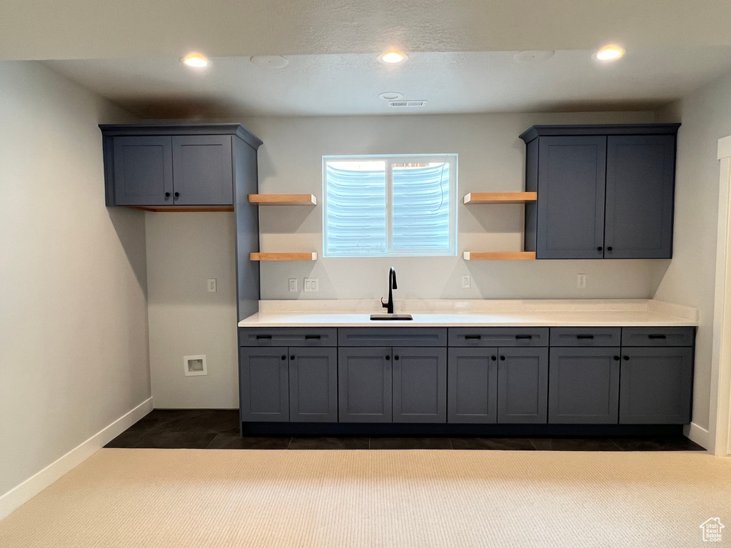 Kitchen with carpet floors, gray cabinets, and sink