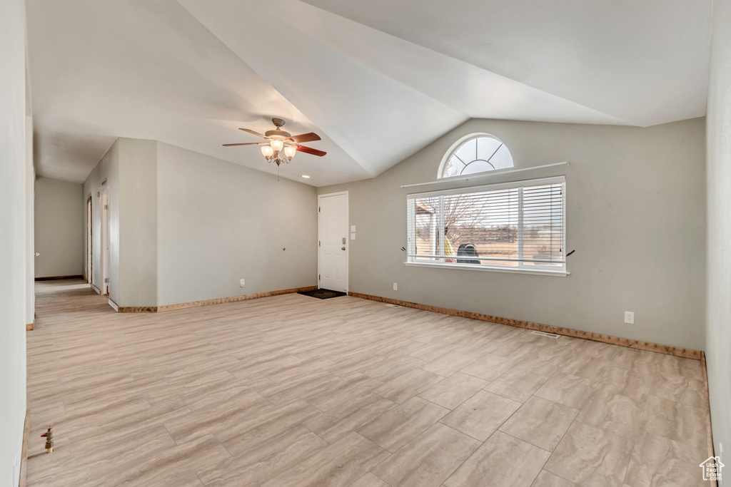 Unfurnished room featuring light hardwood / wood-style floors, vaulted ceiling, and ceiling fan