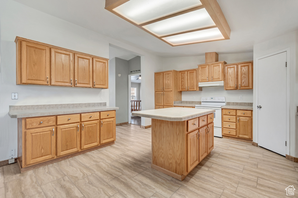 Kitchen with a kitchen island, vaulted ceiling, and electric range