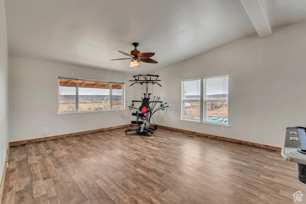 Workout area with lofted ceiling, ceiling fan, and light hardwood / wood-style flooring