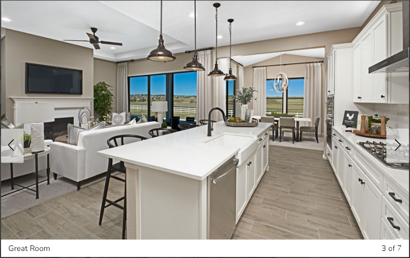 Kitchen featuring a kitchen breakfast bar, ceiling fan with notable chandelier, a center island with sink, hanging light fixtures, and sink