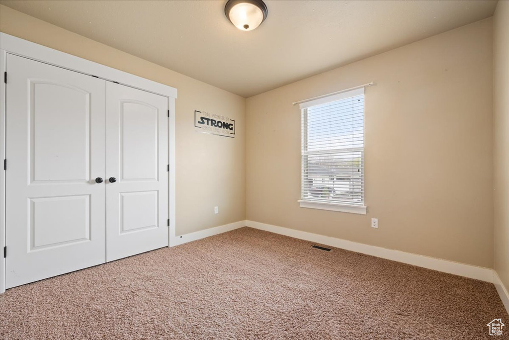 Interior space featuring a closet and light carpet