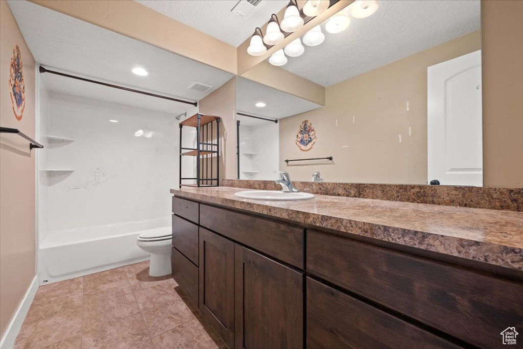 Full bathroom featuring toilet, tub / shower combination, tile floors, a textured ceiling, and vanity