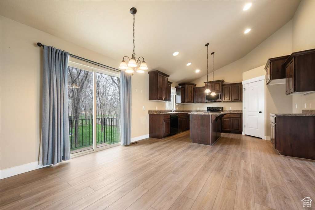Kitchen with hanging light fixtures, light hardwood / wood-style floors, a notable chandelier, and a center island