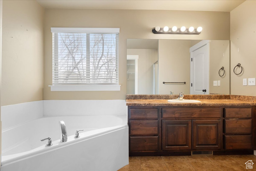 Bathroom with a tub, tile floors, and vanity