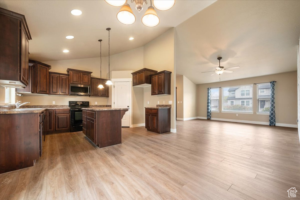 Kitchen with decorative light fixtures, ceiling fan, a kitchen island, and light hardwood / wood-style floors
