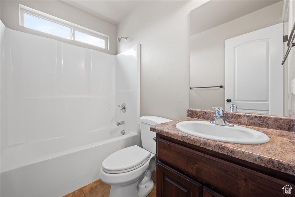 Full bathroom with tile floors, shower / washtub combination, toilet, and vanity