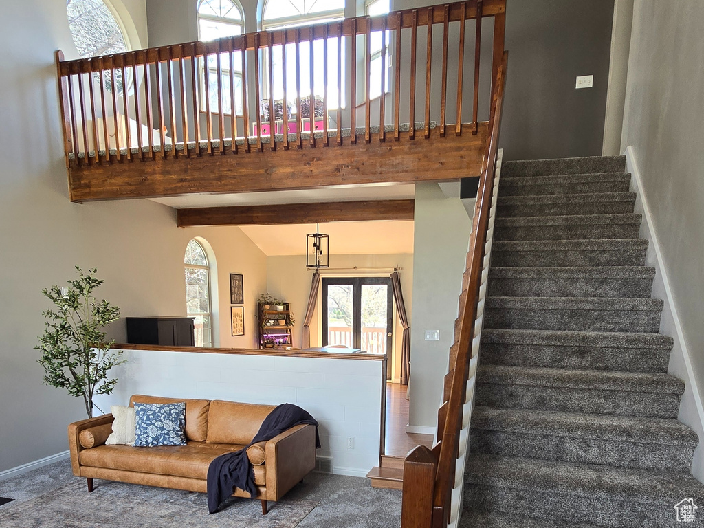Stairway featuring a healthy amount of sunlight, ceiling fan, hardwood / wood-style flooring, and a towering ceiling