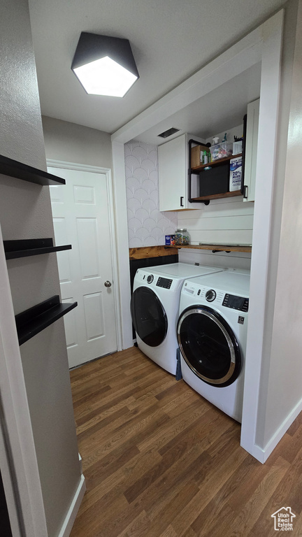 Laundry area with dark hardwood / wood-style floors and washer and dryer