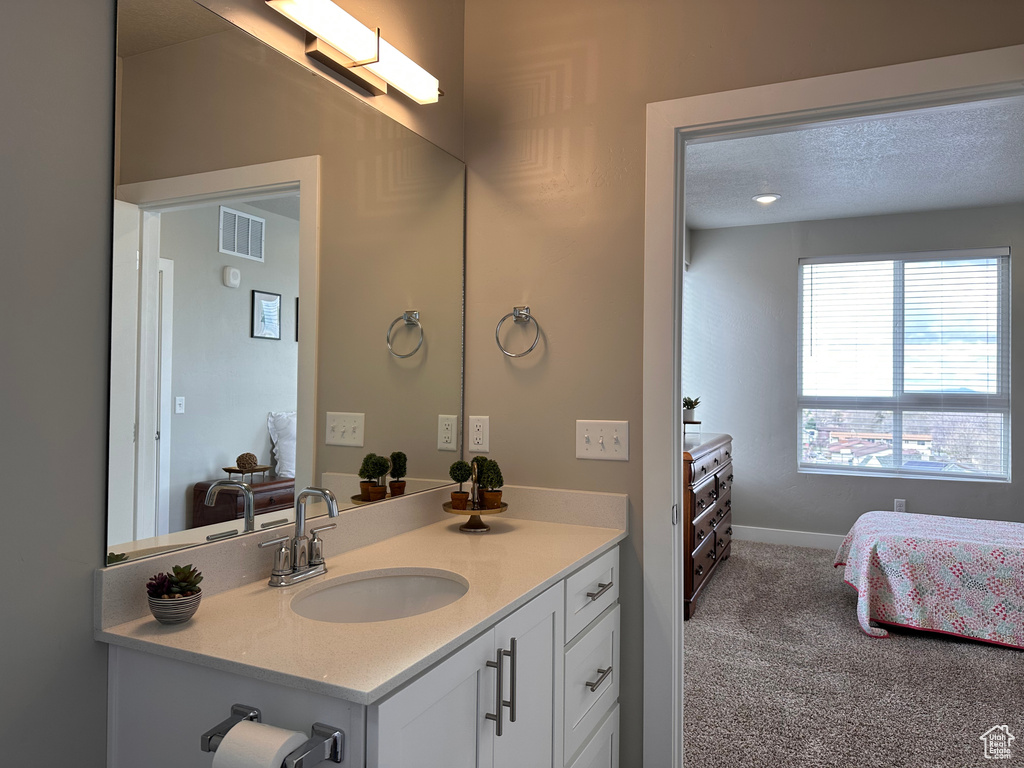 Bathroom featuring a textured ceiling and vanity