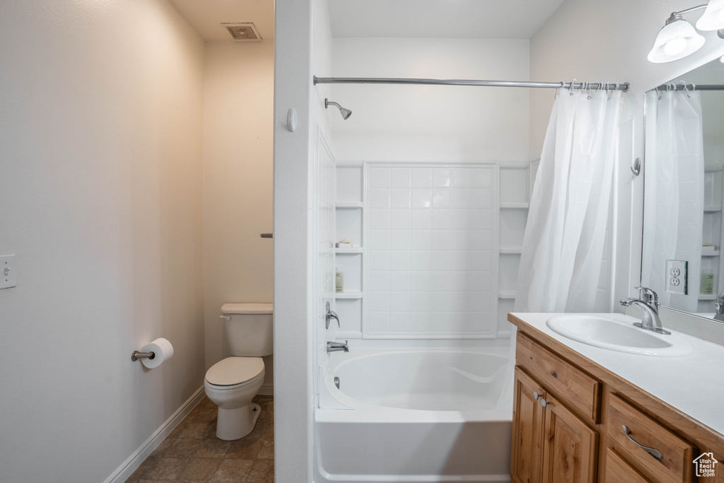 Full bathroom featuring shower / tub combo, toilet, tile floors, and vanity