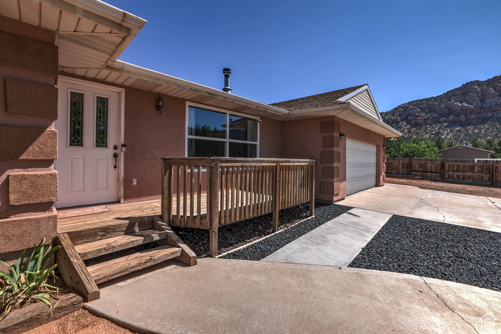 Exterior space with a patio area, a deck with mountain view, and a garage