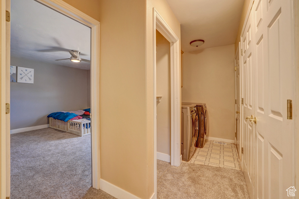 Hallway featuring light carpet and washer and dryer