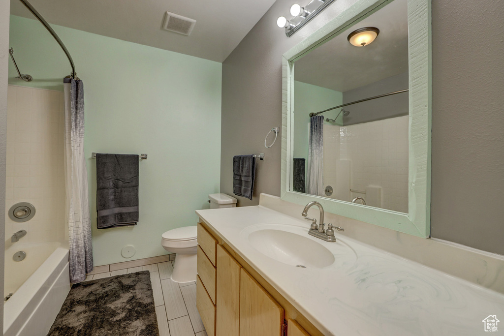 Full bathroom with shower / bath combination with curtain, tile flooring, toilet, and vanity